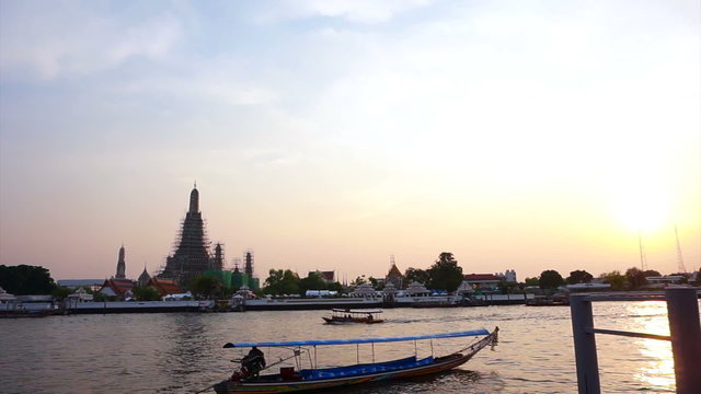 Chao Phraya river in Bangkok, Thailand. Boats traffic transportation in the evening with temple of dawn background 