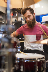 male musician playing cymbals at music store