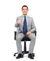 happy businessman  sitting in office chair