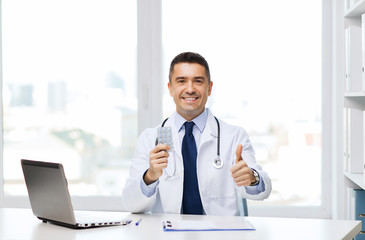 Fototapeta premium smiling doctor with tablets showing thumbs up