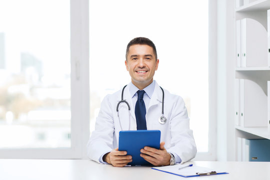 Smiling Male Doctor In White Coat With Tablet Pc