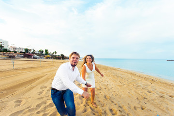 Fototapeta premium happy couple running on the beach