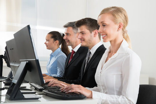 Businesspeople Typing On Desktop Computer