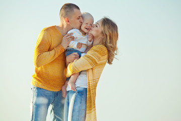 Happy family are playing with son on the beach 