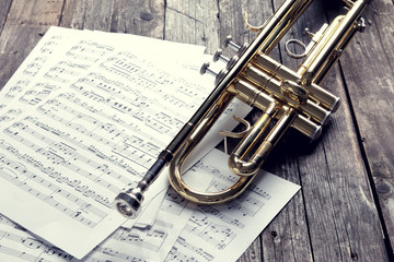 Trumpet and sheet music on old wooden table. Vintage style. - 94207797