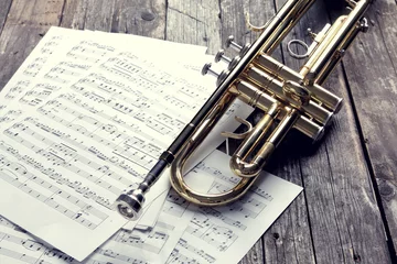Rolgordijnen Trumpet and sheet music on old wooden table. Vintage style. © Zerophoto