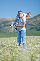 Happy father are playing with son in camomile field