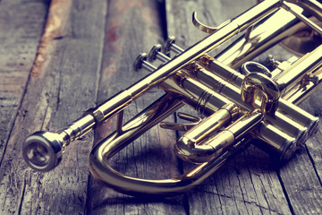 Trumpet on an old wooden table. Vintage style.
