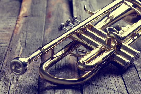 Trumpet on an old wooden table. Vintage style.
