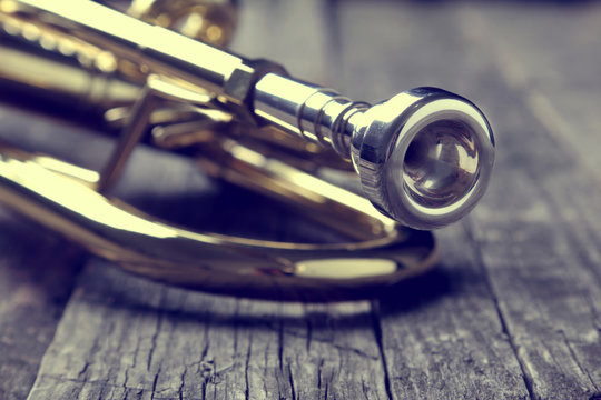 Trumpet on an old wooden table. Vintage style.
