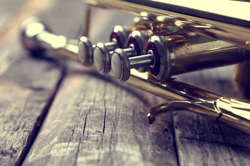 Trumpet on an old wooden table. Vintage style.