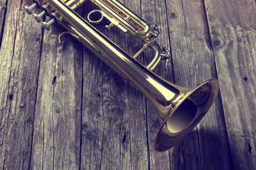 Trumpet on an old wooden table. Vintage style.