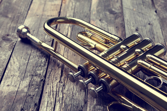 Trumpet on an old wooden table. Vintage style.