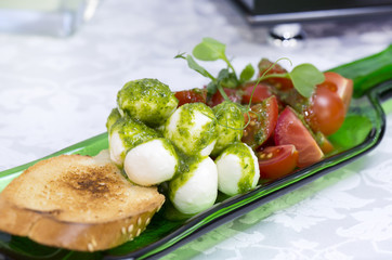 Caprese salad with tomatoes and cheese in a plate of glass