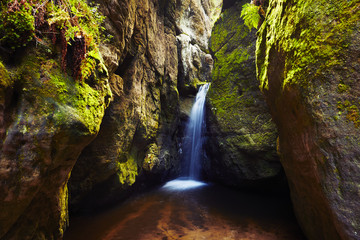 Waterfall among rock walls