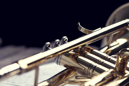 Trumpet and sheet music on old wooden table. Vintage style.
