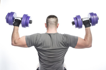 Back view of muscular man in gloves holding dumbbells under head