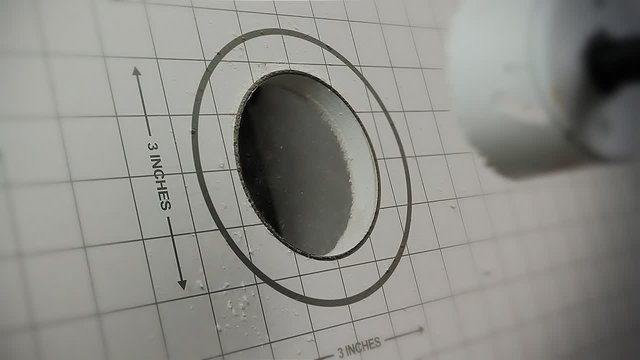 Drilling A Hole In Drywall. 2 shots. 1st shot shows the distance and diameter as the whole is drilled in the wall. 2nd shot has no grid or graphics on it.
