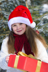 Portrait of smiling  little girl with christmas gift im winter forest