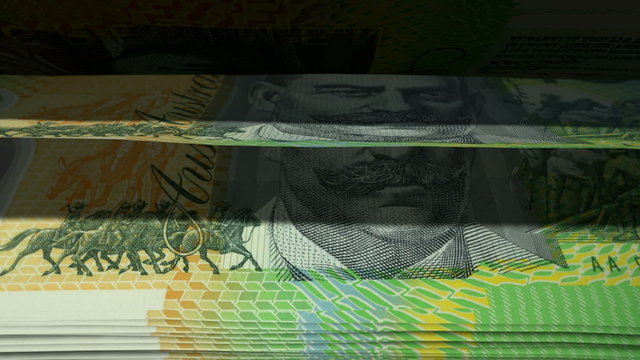 An extreme closeup of australian dollar banknotes flipping through in a counting machine