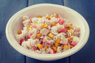 fish salad on white bowl on blue wooden background