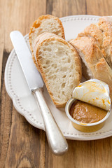 bread with fish pate on white plate on brown wooden background