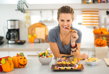 Smiling woman eating trick or treat halloween candy