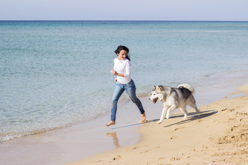 Girl running with her dog on beach