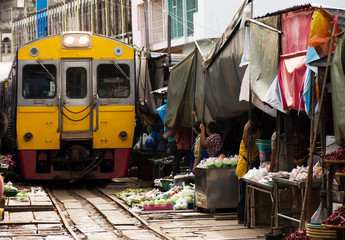 Naklejka premium Train drives over the market of Maeklong in thailand