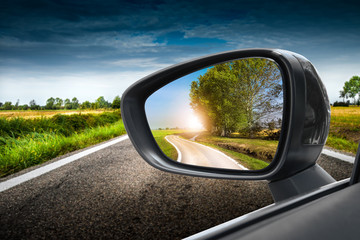 strada di campagna riflessa nello specchio retrovisore - 94217543
