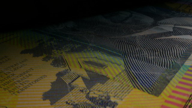 An extreme closeup of australian dollar banknotes flipping through in a counting machine
