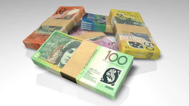 An extreme closeup pan around of a scattered pile of bundled increments of australian dollar bank notes on an isolated background