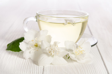 Fototapeta na wymiar Glass cup of tea with jasmine on the white background
