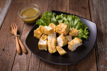 Fried bean curd eaten with sauce on the black dish