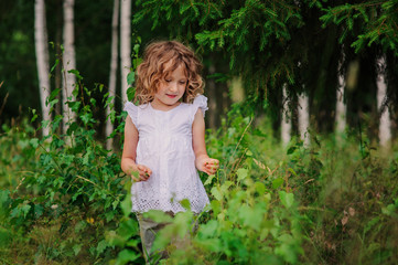 child girl exploring nature on the walk in summer forest on vacation