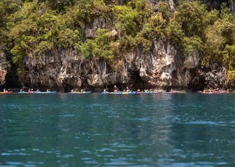 Fototapeta na wymiar group kayaking among the rocks by the sea.