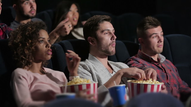 A group of people watching a movie showing emotion