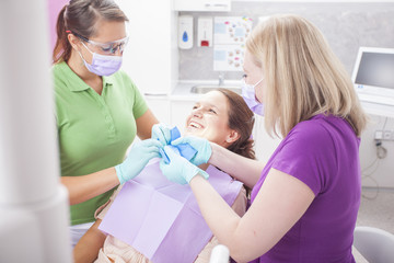 Female dentist and her female asisstant installing a rubber dam