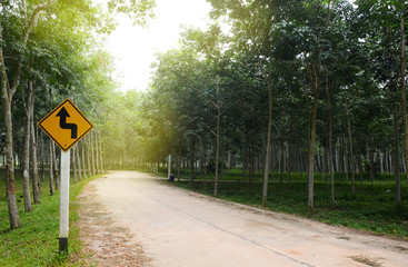 reverse turn left signs on the road on the road in a rubber plantation