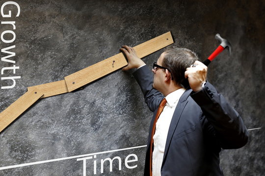 businessman nailed growth chart on wall