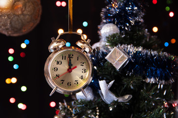 Fototapeta na wymiar clock ,a decorated Christmas tree on a black background with lig