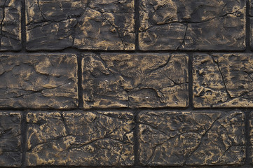 The wall built of blocks of dark color