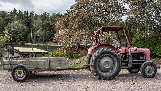 Retro red old tractor with a chariot