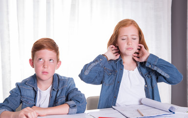 two kids are annoyed doing their homework