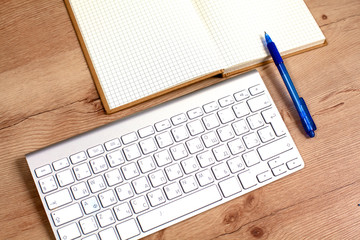 Office table with blank notepad and laptop 