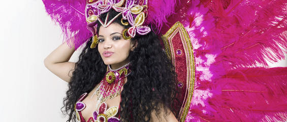 Samba dancer wearing traditional pink costume while posing lette