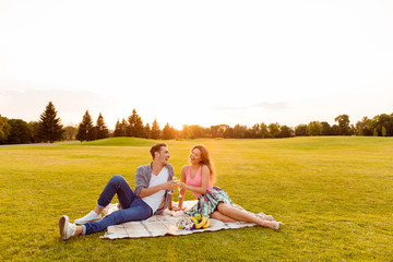 Cheers! Young man and woman at picnic