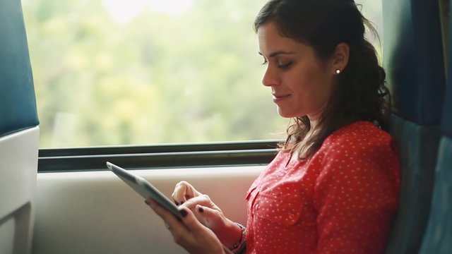Woman using a tablet inside a moving train
