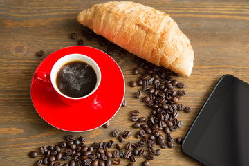 Coffee cup and beans, with croissant and tablet pc