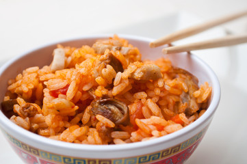 bol de riz aux légumes et bolets avec des baguettes chinoises